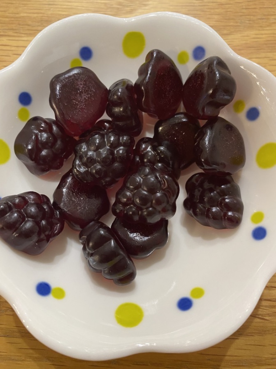 皿に出した果汁グミ。ぶどうの粒を模した濃い紫色のグミ